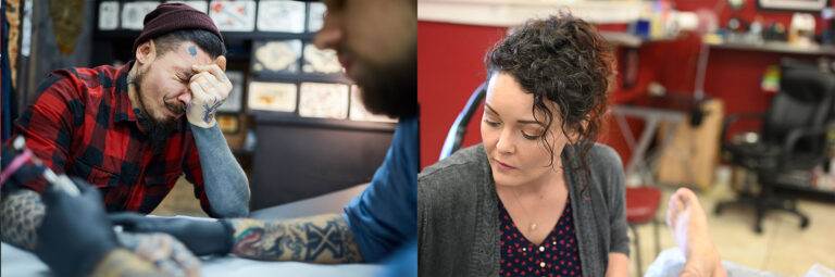 A man in a red flannel shirt and beanie grimaces while getting a tattoo. Beside, a woman looks over as she gets a tattoo on her foot in a tattoo studio.